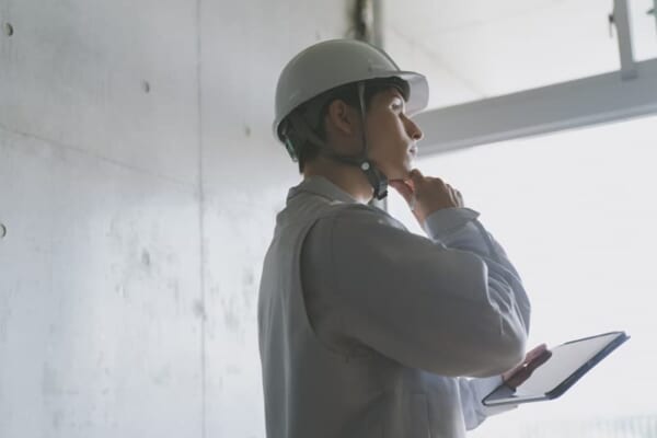 工事現場で考え込んでいる男性